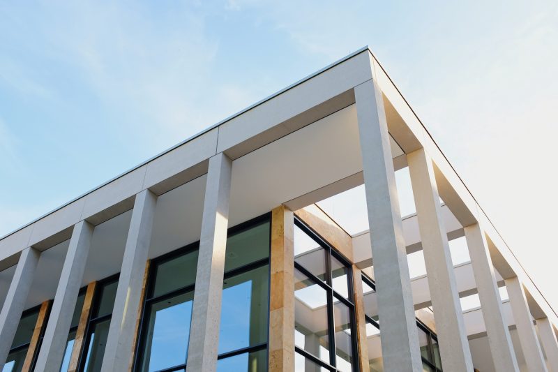 Corner of a modern building with a blue sky background representing open architecture investing.